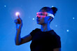 © VISTA by Westend61 - Woman interacting with a holographic interface wearing VR glasses in a futuristic setting