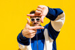 © VISTA by Westend61 - Man in urban clothing posing with hand frame gesture against a yellow background