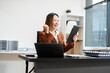 © NINENII - Happy Asian woman holding a smartphone, happy smiling, getting bonus money..