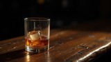 Vaso de whisky con hielo en un ambiente de bar melancólico con poca iluminación y espacio para copiar