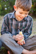 © Austockphoto - Cute boy smiling and holding a pet chicken in the backyard