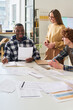 © Mediaphotos - Students of diverse backgrounds studying foreign languages in bright classroom environment, collaborating on group projects with notes and papers spread on desks
