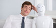 © SnowElf - Smiling man in white shirt and tie leans against a white robot with a happy face. Both appear content in a friendly manner, embracing technology with human interaction in an office setting