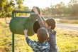 © Austockphoto - Two boys checking the mailbox for mail in the golden afternoon light
