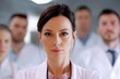 © Constantinos - Confident female doctor in a team of healthcare professionals.  Serious expression, focus on her.