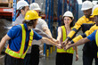 © eakgrungenerd - Group of warehouse workers Join hands each other, showing teamwork and camaraderie after finishing significant task successfully. Atmosphere lively and encouraging.