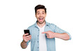 © deagreez - Photo of handsome guy holding telephone hand indicating finger advising cool offer price for smart phone wear denim shirt isolated green color background