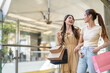 © Art_Photo - Two happy asian woman shopping together in a mall carrying shopping bags enjoying retail therapy, friendship and leisure, trendy fashion, lifestyle and happiness, young women in modern shopping center