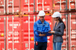 © DG PhotoStock - Businesswoman and logistic or shipyard engineer have a discussion or business due at container yard.