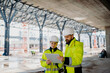 © Halfpoint - Engineers discussing construction plans using a tablet on site.
