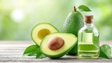 Fresh avocado and oil bottle on wooden table with green leaves