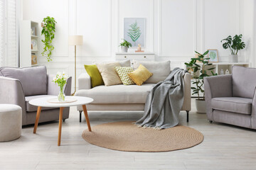 Poster - Stylish furniture and houseplants in light living room. Interior design