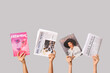 © Pixel-Shot - Female hands with different magazines and newspapers on grey background