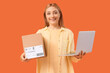 © Pixel-Shot - Female online store seller with parcel and laptop on orange background