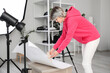 © Pixel-Shot - Beautiful young female photographer with professional camera and vase working in studio