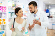 © JackF - Woman asking questions about skin care product during consultation with man druggist.