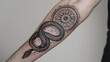 © Atthapon - A black and white tattoo of a snake with a sun on its back