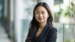 © Dara - An Asian accountant posing for a portrait with a friendly smile, exuding competence and reliability in their profession.