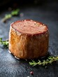 © EpicFade - Exquisite closeup of a juicy tenderloin steak on a dark slate stone surface with thyme sprigs highlighting the rich texture and appetizing presentation for culinary excellence