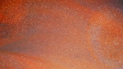 Wall Mural - shimmering ink texture, abstract macro view with orange and metallic sparkle tones
