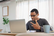 © eggeeggjiew - Confident African American man wearing glasses having video call meeting on laptop at home office, gesturing while talking, remote work concept.