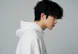© Iram - Asian young man in white hoodie, side profile of handsome male model with black hair, minimalist studio portrait of youth fashion