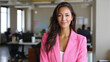 © Keitma - Confident businesswoman wearing pink blazer standing in modern office with a professional smile