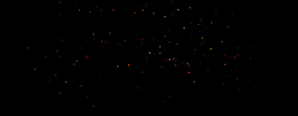 Wall Mural - panoramic blurred fire embers sparks on black background . texture isolated overlays. concept of par