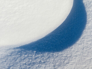 Wall Mural - beautiful winter background with snowy ground. natural snow texture. wind sculpted patterns on snow 