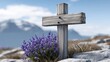 © watcharee - A weathered wooden cross stands among purple wildflowers on a rocky mountain landscape with snowy peaks in the distance.