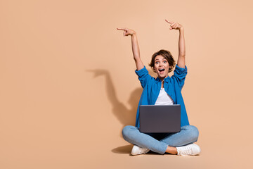 full length size photo of amazed woman sitting with macbook pro pointing fingers novelty apple visio