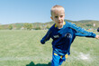 © Elena - Young Boy Joyfully Playing on Soccer Field