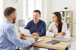 © Studio Romantic - Office meeting, young confident business people signing contract at group negotiations, business partners making successful investment deal, agreement, salesman discussing, successful negotiate