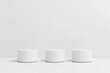 © arifat - Three white cylinder podiums on a white wall