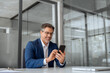 © Stock 4 You - Senior financial specialist, investor entrepreneur man holding cellphone telephone for work sitting at desk. Smiling mature ceo businessman using sale phone application for business trade in office