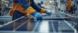 © วิทวัส วงษ์หาจักร์ - Worker assembling solar panels in a factory.