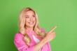 © deagreez - Smiling woman in pink shirt gesturing with hand against green background, portraying happiness and positive emotions.