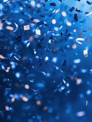 Wall Mural - blue confetti falling on a blue background with bokeh and copy space for design.