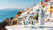 © Myroslava - Bottle of traditional Greek Ouzo with blank mockup label and short glasses served on an outdoor table against the backdrop of the coast.