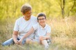 © Serhii - Grandmother walking with her grandson. Relaxing and joying in sunset