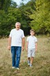 © Serhii - Happy weekend concept. happy grandfather and grandson are walking in the park