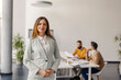 © Dusan Petkovic - Corporate female white collar worker standing at boardroom during the meeting in a background and looking at camera.