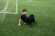 © ADDICTIVE STOCK - Young boy smiling while sitting on soccer field astro turf
