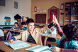 © Marko Geber - Happy school kids high fiving in classroom after finishing assignment