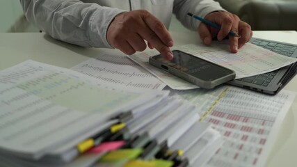 Wall Mural - businessman uses a calculator and paperwork to analyze finances, investments, and tax reports at his desk calculator and digital tablet. business financial reports and data analysis				
