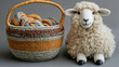 © abid - Knitted basket with colorful yarn and a sheep figurine against gray background