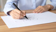 © Tomsdoingstuff - Woman Drawing Family Tree at Wooden Table, Closeup View of Hands Creating Genealogy Chart for Ancestry and Heritage Projects