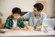 © Kittipong - The father is teaching his son his homework with care at his home.