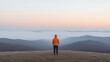 © Bella - Solitude on a mountaintop at sunrise.  A person stands alone, contemplating the vastness of a misty mountain landscape