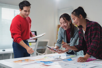 Wall Mural - three asian web designers are collaborating on a project. analyzing mobile app layouts and uiux desi